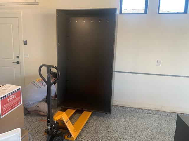 Pallet jack positioned under cabinet for lifting